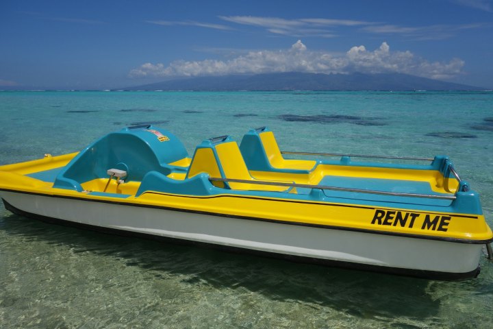 a blue and white boat sitting next to a body of water